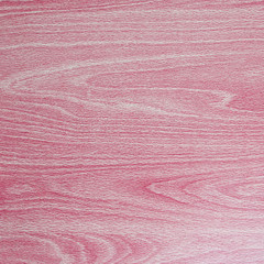 Red / pink background texture of curvy patterns in wood grain.