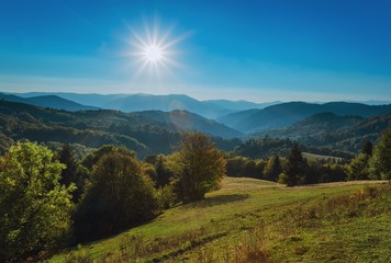 Carpathian Mountains. The autumn sun with rays, mountains and hills