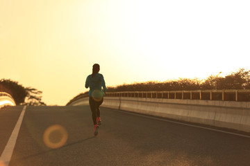 Fototapeta premium young fitness woman runner running on sunrise road