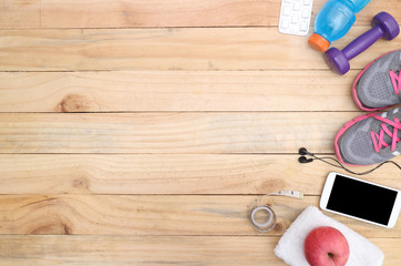 Sport equipment.  water, towel, earphones and phone on wooden background