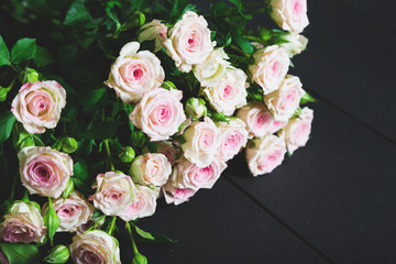 Bouquet of roses on a black wooden table
