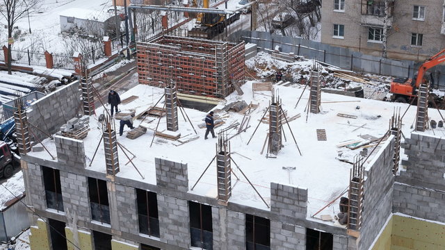 ODINTSOVO, RUSSIA - February 15, 2015. Construction of administrative building in a residential area. Workers operate construction equipment. Winter.