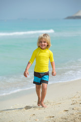 Fototapeta na wymiar Smiling little boy running on the beach