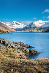 Layer of snow on mountain peaks at Wast Water Lake in the English Lake District on a beautiful sunny day.