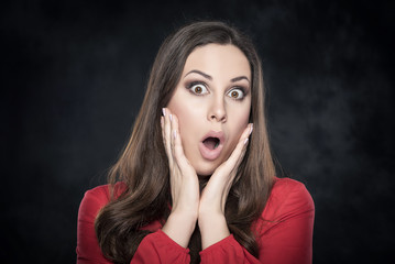 Excited woman over dark background.