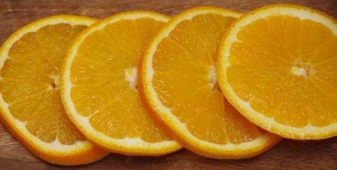 round slices of orange on a wooden brown background