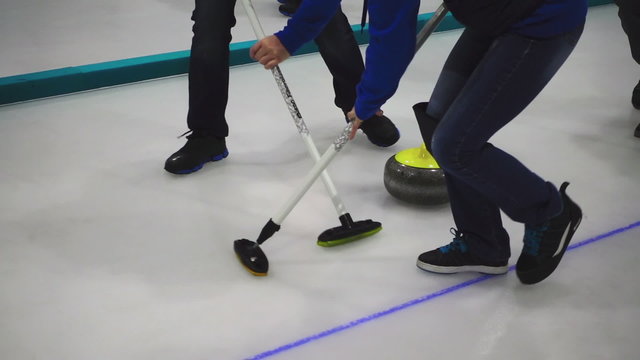 Curling stone slide, players sweeping