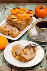Homemade persimmon cake with fresh persimmons and black tea