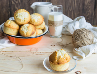 glass of milk with muffins on wooden table