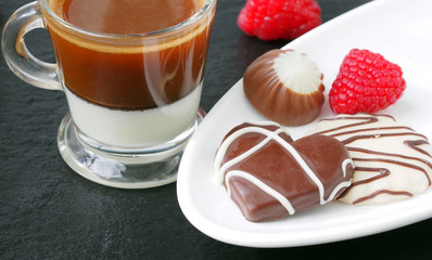 Сup of espresso wits milk and chocolate candies