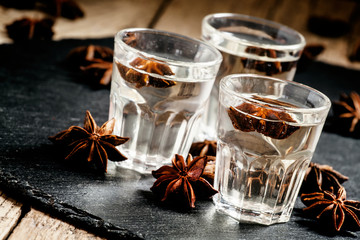 Homemade anise liqueur in a glass on a dark background, selectiv