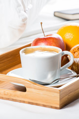 Breakfast tray in bed. Cup of coffee. Fruit.