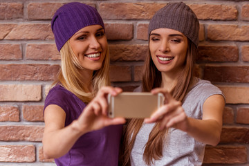 Beautiful girls posing with gadget