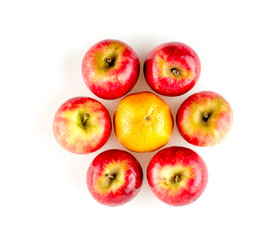 Apples surrounding one orange arranged in circular flower shape
