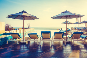 Umbrella and chair around swimming pool