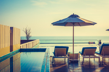 Umbrella and chair around swimming pool