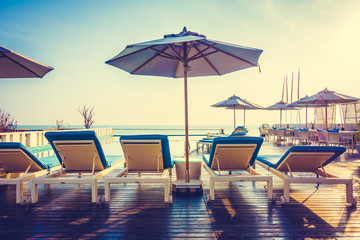 Umbrella and chair around swimming pool