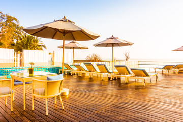 Umbrella and chair around swimming pool