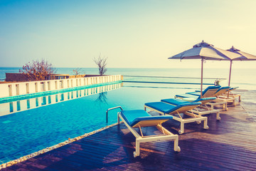 Umbrella and chair around swimming pool