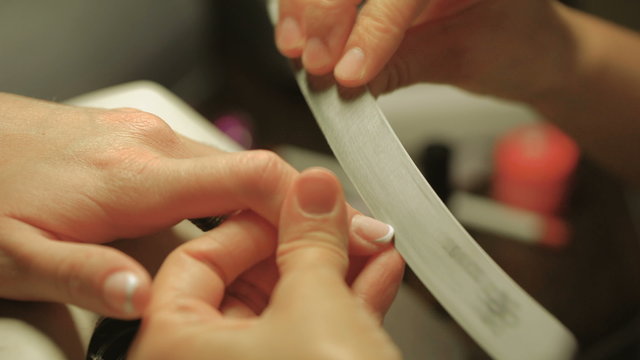 Manicure and Hands Spa. Woman in a Beauty Nail Salon receiving a manicure by a beautician. Gentle care of nails in a beauty salon. Manicure process