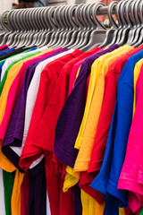 Various colored T-shirts on hangers