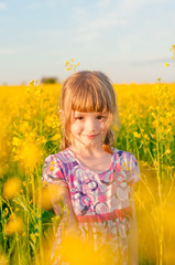 Girl with pigtails in a field of yellow flowers