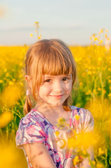 Girl with pigtails in a field of yellow flowers