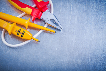 Electric tester pliers on metallic background electricity concep
