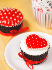 Delicious cupcake with red heart frosting