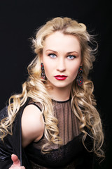 Fototapeta premium Beautiful fashion model girl with blond hair. Portrait of glamour woman with bright makeup isolated on black background.