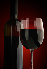 Elegant wine glass and a wine bottle in black background