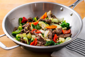 Healthy vegetable & beef stir-fry. Made with flank steak, peppers, onions and bok choy stir fried in an asian wok. - obrazy, fototapety, plakaty