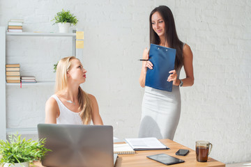 Two young woman colleague at office working standing and talking