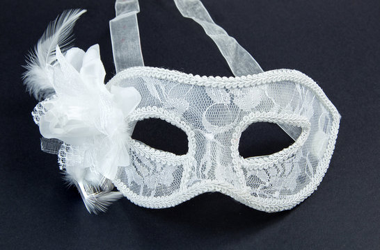 White laced carnival mask on black