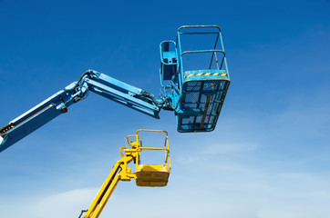 Two crane's baskets against clear sky