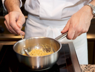 Chef is preparing dish with noodles