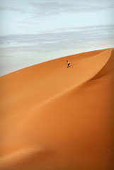Skateboarder rides on the dunes in the Sahara Desert