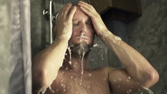 Young man washing his face under shower, super slow motion 240fps 
