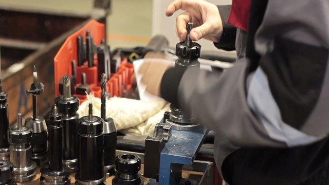 Close-up mechanical industrial worker measuring detail in tool workshop.