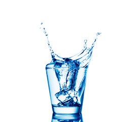 Ice cubes splashing into glass of water, isolated on white