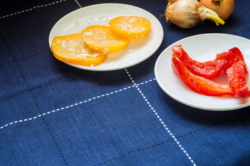 Red peppers with marinated zucchini on a blue table. Frozen pepp