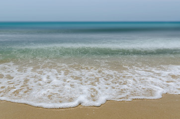 Waves and sand close up with blurred background