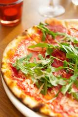 Mozzerella pizza with arugula salad on table