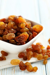 Dried raisins on a blue wooden table