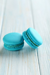 Tasty blue macarons on a blue wooden table