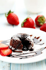 Chocolate fondant with strawberry on blue wooden table