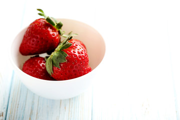 Ripe red strawberry on a blue wooden table
