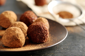 Sweet chocolate truffle on a black wooden table