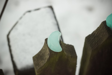 Green handmade ice cube moon shape form closeup on wooden picket