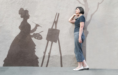 Достопримечательность Одессы. Женщина позирует на фоне изображения, нанесенного на  бетонном заборе улицы - Карантинный спуск.